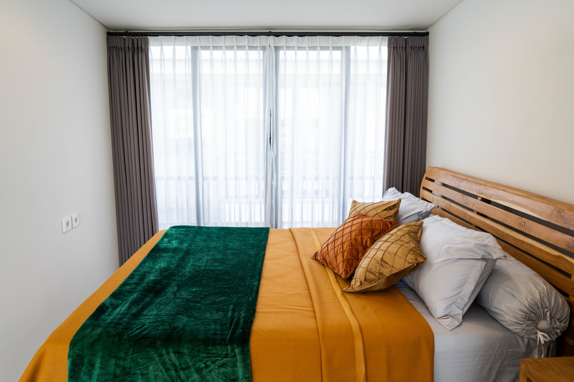 Bedroom detail with green and ochre bedding